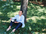 木の下で読書をする男性